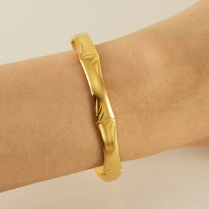 Detailed close-up of a 18K gold-plated stainless steel bamboo style bracelet on a wrist