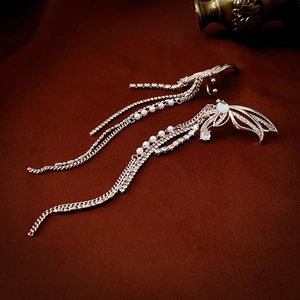 Detailed close-up of silver angel wing ear cuffs with cubic zirconia and pearl tassels