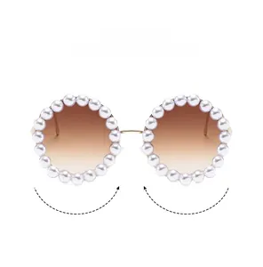 Detailed view of round sunglasses featuring pearl-encrusted frames and gold metal temples