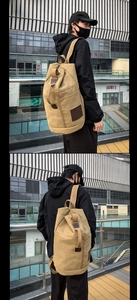 Detailed street view of khaki canvas duffel backpack showing side and front carry styles