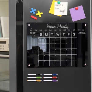 Close-up of magnetic acrylic fridge calendar with weekly planner and colorful markers