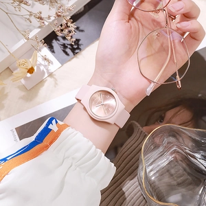 Close-up of pink silicone watch on wrist with rose gold dial and Arabic numerals