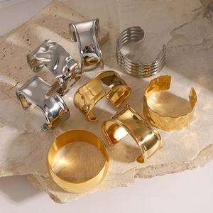Close-up of gold and silver hammered metal bangles on natural travertine stone