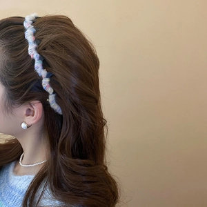 Detail of colorful woven wave headband worn by model with soft aesthetic style