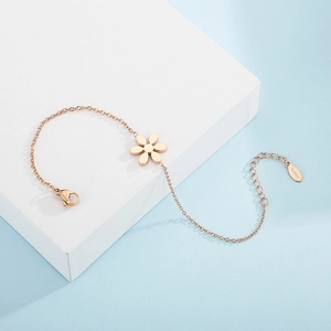 Detail shot of rose gold stainless steel flower bracelet on geometric white podium