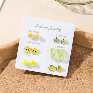 Detail view of 6-pair weekly stud earring set featuring yellow stars and green bears