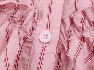 Detail von rosa gestreiftem Stoff mit Rüschenkanten und passendem Vier-Loch-Knopfverschluss