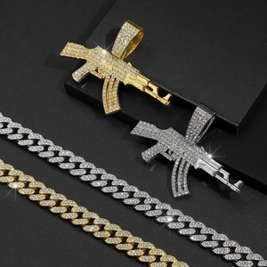 Gros plan de pendentifs AK47 sertis de diamants en or et argent avec chaînes cubaines