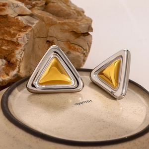 Nahaufnahme geometrischer Dreieck-Ohrringe in poliertem Gold- und Silber-Finish