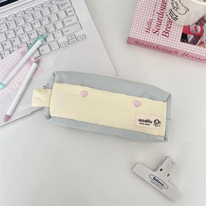 Detail of light blue and cream stationery pouch with soft fabric and pink heart patches
