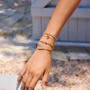 Golden multi-layer bracelet set for women featuring a red heart pendant and crystal accents