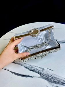 Detail of silver rhinestone evening clutch showing satin lining and detachable chain