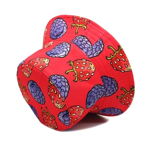 Detail of vibrant red bucket hat featuring realistic strawberry and raspberry fruit patterns