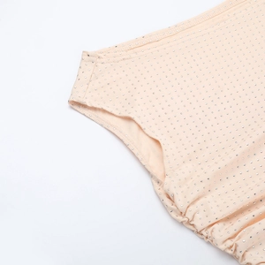 Détail de la robe champagne avec des strass brillants sur un tissu élastique délicat