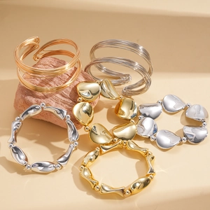 Detail view of five-piece geometric gold and silver metallic bangle and bracelet set