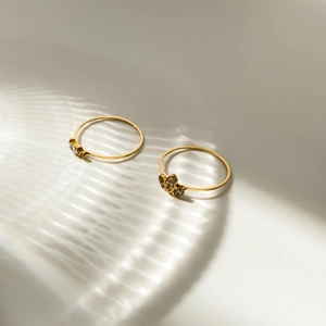 Detailed view of two gold crystal rings with water ripple light shadows