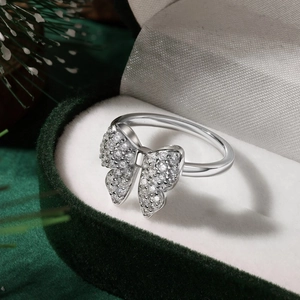 Macro shot of silver butterfly ring with pavé stones in a green velvet jewelry box