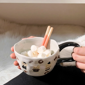 Close-up of ceramic bear mug filled with marshmallows and pink biscuit sticks