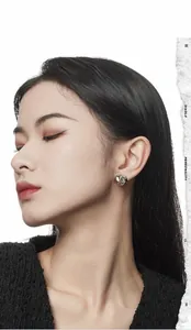 Close-up of minimalist irregular liquid silver stud earrings on model with high gloss finish