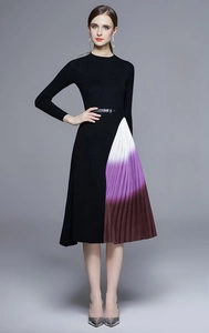 Détail de robe plissée en maille montrant la jupe dégradée violette et la ceinture