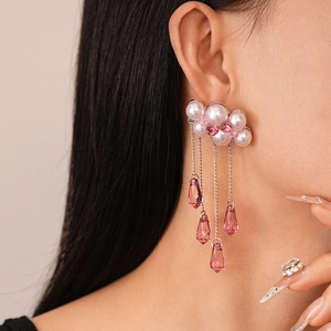 Close-up of pink pearl earrings with silver chain tassels and crystal water drop charms