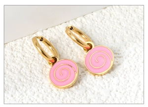 Macro detail of 18K gold stainless steel hoop earrings with pink enamel spiral charms
