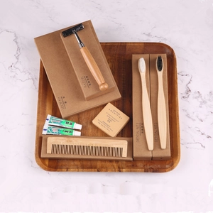 Eco-friendly bamboo toiletries set with razor, toothbrushes and soap on wood tray
