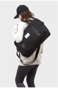 Close-up of black quilted gym bag showing large capacity and water-resistant nylon fabric