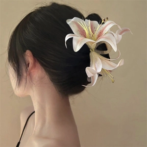 Detailed back view of a white and pink lily hair claw clip styling an elegant updo