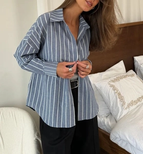Détail de chemise en coton à rayures bleues et blanches avec col à revers et poignets boutonnés