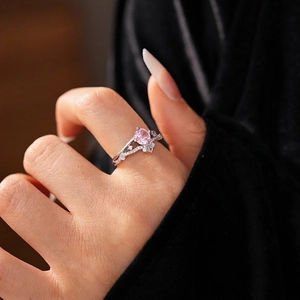 Elegant silver-tone ring featuring an oval pink gemstone with sparkling zirconia accents