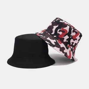 Detail of reversible bucket hats in black and pink camouflage patterns for sun protection