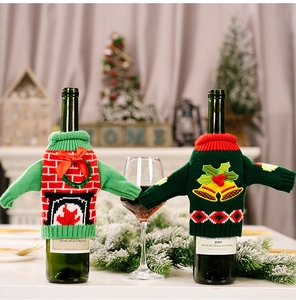 Close-up of knitted Christmas wine bottle covers with 3D fireplace and bell patterns