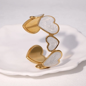 Bracelet jonc ouvert en acier doré 18 carats avec cœurs émaillés blancs sur coupelle