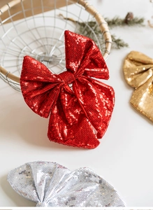 Close-up of sparkling sequin Christmas bows in red, gold and silver for tree decoration
