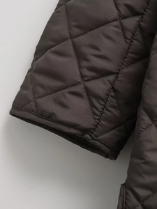 Close-up of the dark brown diamond-quilted cuff showing detailed stitching and fabric texture