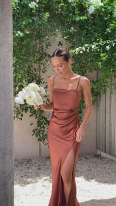 Detailed view of rust red satin slip dress with high side slit and gathered waist detail