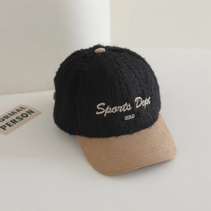 Détail de la casquette pelucheuse noire avec visière en velours côtelé kaki et broderie