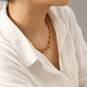 18K gold plated stainless steel knotted chain necklace worn by a fashion model