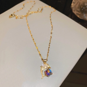 Detailed close-up of a golden dolphin pendant featuring a colorful cubic gemstone and diamonds