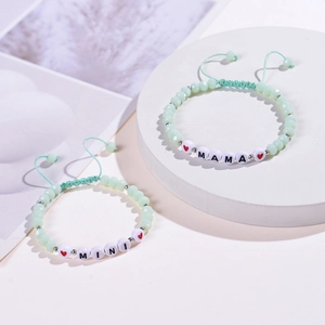Detail of mint green beaded mother-daughter bracelet set with MAMA and MINI charms