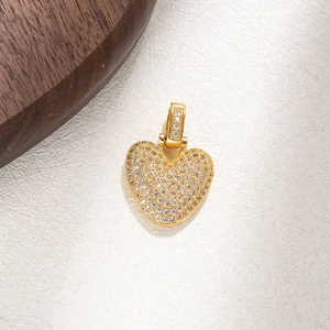 Close-up of a gold heart pendant featuring micro-pave set sparkling cubic zirconia crystals
