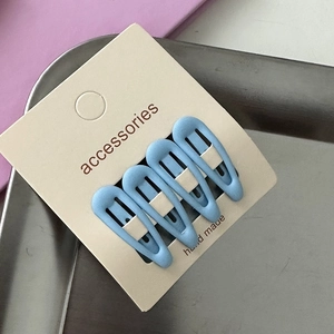 Set of 4 blue matte drop-shaped hair clips for girls on a handmade card display