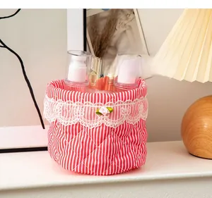 Detail of red striped fabric organizer bin with white lace trim and floral accent