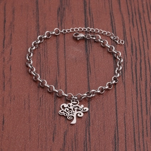 Silver tree of life stainless steel bracelet with lobster clasp on dark wooden background
