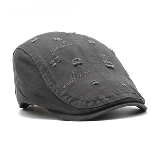 Detail of dark grey cotton beret with fashion embroidery and vintage distressed finish