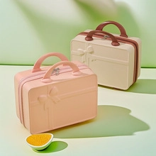 Detail of 14-inch mini suitcases in pink and beige with embossed bow decoration
