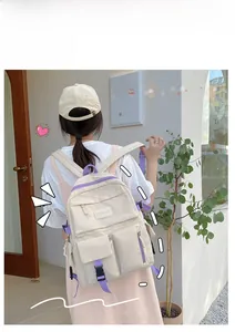 Detailed view of the multi-pocket nylon backpack with contrast purple straps and buckles
