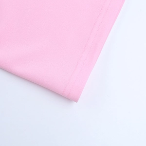 Detail of pink dress hem showing precise double-needle stitching and fabric texture