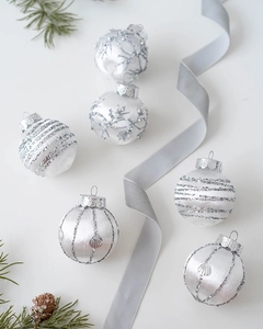 Detailed view of silver Christmas ornaments set with glitter texture and pine cone accents